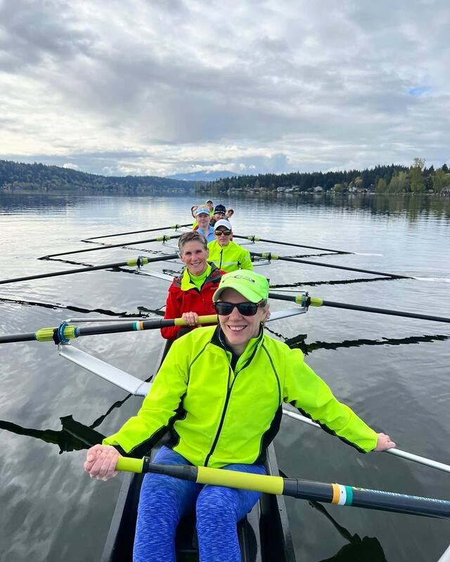 Rowers in bright colors smile for a picture. 