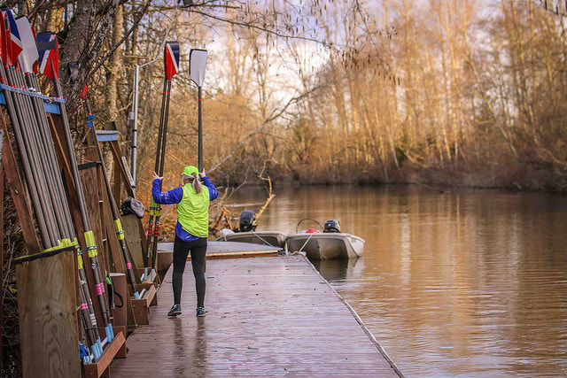 An SRA rower returns oars to their storage area on the dock. 