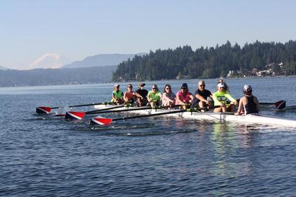 An eight with novice rowers is pictured on Lake Sammamish with Mount Rainier in the background. 